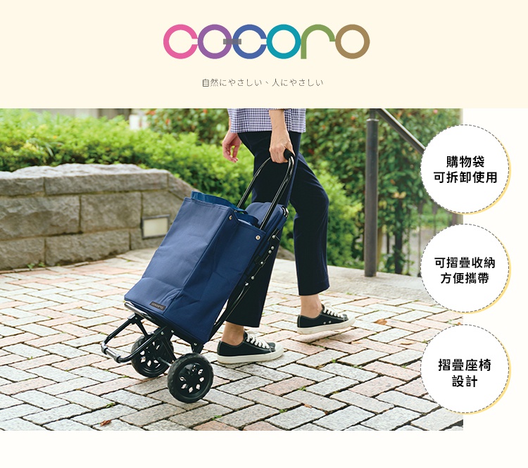 一位身穿休閒服飾的人在石磚路面上推著 COCORO 深藍色多功能摺疊購物車。購物車設有兩個輪子，旁邊的三個圓圈文字標註了購物袋可拆卸使用、方便摺疊收納，以及具備摺疊座椅設計。
