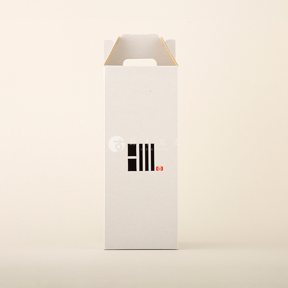 無印八女迷你裝飾提燈的紙盒包裝，盒身為灰白色，頂部有提把設計。盒身中央印有黑色線條組成的圖案，以及紅色圓形標誌。