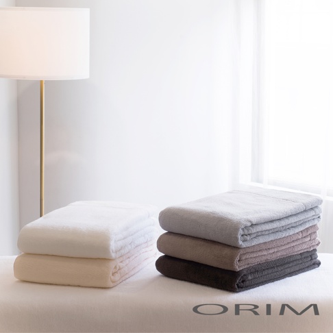 兩疊今治輕羽恆柔耐久輕質毯，一疊為白色和米色，另一疊為淺灰、灰褐色、紫褐色和深灰色，材質柔軟。