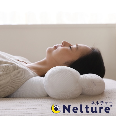 一名女子側臥，頭部枕於一個白色網狀材質的安睡枕上。安睡枕由多個圓柱狀和球狀部分組成，設計貼合頸部曲線。