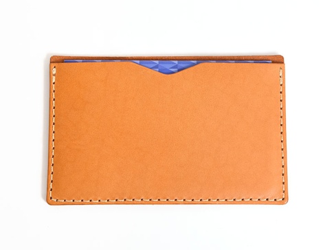 職人手作皮革存摺文件收納夾，採用淺棕色皮革製成，配有米白色縫線。收納夾內側可見紫色幾何圖案內襯。