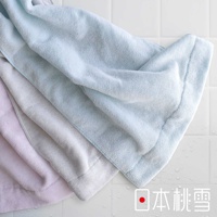 三條疊放的迷你浴巾，顏色分別為淡粉色、淺灰色和淺藍色。浴巾材質呈現柔軟蓬鬆的毛圈織法，邊緣有明顯的包邊處理。