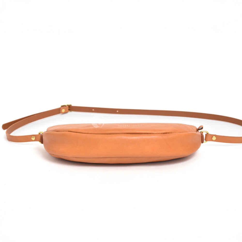 日本HERZ職人手作皮革半圓馬鞍包CK-17，駝色皮革，從側邊拍攝，展示了包包的圓潤弧度與細節。