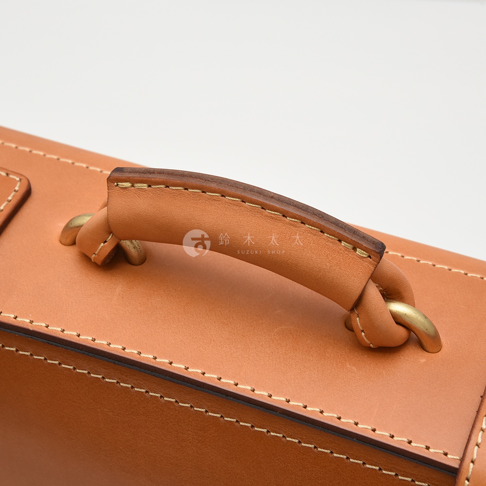 職人手作皮革機師箱 BC-31 提把細節，使用棕色皮革與黃銅五金件，手工縫線整齊。