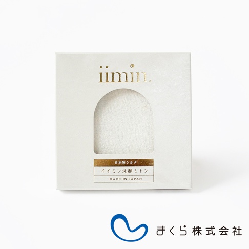 iimin 蠶絲洗臉手套，白色紙盒包裝，盒面有拱形透明開窗，露出內部的白色蠶絲洗臉手套，下方有金色標籤，標示「日本製シルク」及「イイミン洗顔ミトン」，並有「MADE IN JAPAN」字樣。
