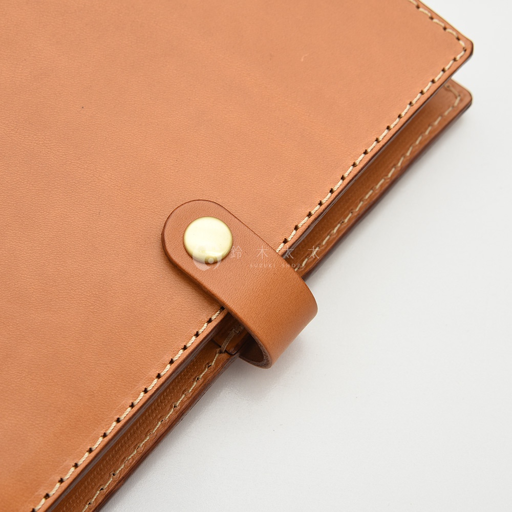 職人手作皮革A5手帳/記事本書套，淺棕色皮革，帶有金色金屬按扣，車縫線清晰，設計簡約。