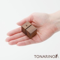 一雙天然實木筆電散熱塊，深棕色，方形，表面光滑，印有細緻的LOGO圖案，置於手掌中。