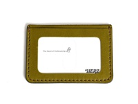 橄欖綠皮革製成的橫式票券夾，有縫線裝飾，正面中央有透明視窗，視窗內有「The Heart of Craftsmanship」字樣和圖案，右下方有「HERZ」品牌標誌。