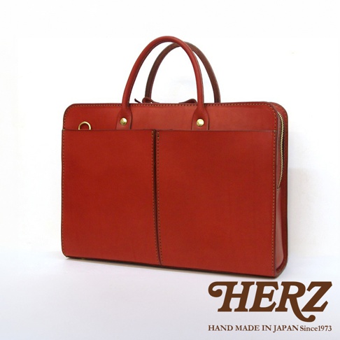 紅色皮革雙口袋商務公事包，帶有雙提把、金色拉鍊和兩個外部口袋。