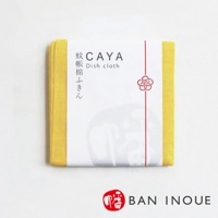 黃色蚊帳布拭巾，邊緣為細緻織紋，包裹著白色品牌標籤，標籤上有日文「蚊帳棉ふきん」和英文「Dish cloth」字樣，以及紅色繩線與梅花圖案。