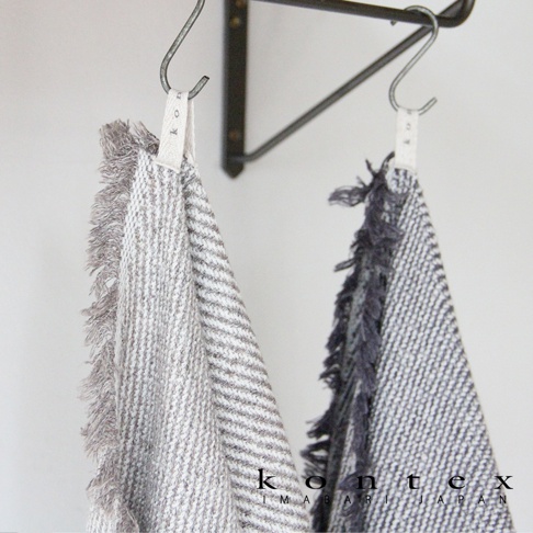 兩條SWELL質感流蘇鬆餅紋浴巾，一條為淺灰色條紋，另一條為深灰色條紋，皆帶有流蘇邊飾，掛在金屬掛架上。