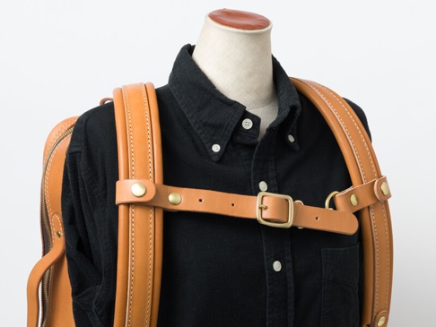 職人手作皮革背包用減壓胸前扣帶，採用鞣製皮革，配有黃銅扣環與鉚釘，連接於背包肩帶之間，用於分散重量。