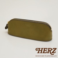 橄欖綠皮革製的職人手作三角弧形收納筆袋，配有金色拉鍊和黑色滾邊，表面壓印有「HERZ」品牌標誌。