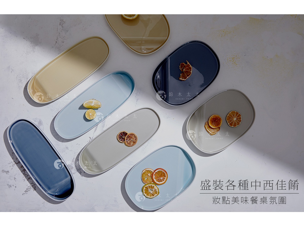 多個波佐見燒可沾醬長型主菜盤，顏色包含深藍、米白、淺藍、灰色，盤中盛放檸檬片、乾燥果片等裝飾，材質為陶瓷。