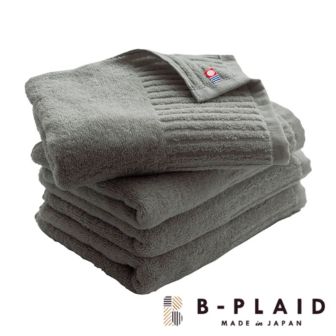 一疊灰色 RIB 今治長毛柔暖速乾直紋浴巾，頂部浴巾角落處有一個品牌標誌，標誌為紅色圓形，內有藍色與白色條紋。