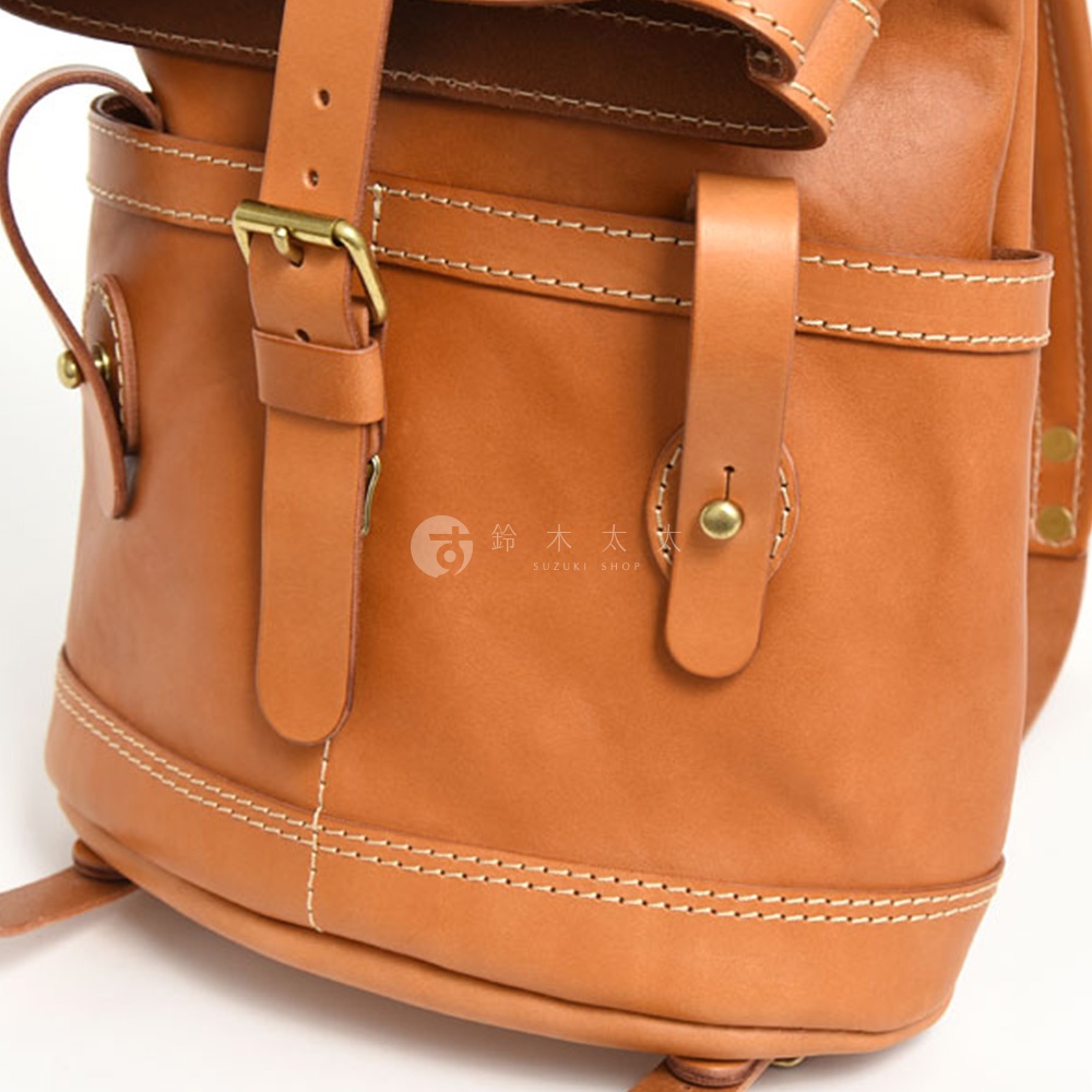 職人手作皮革雙口袋折蓋後背包，採用棕色皮革材質，配有黃銅色金屬釦具和白色縫線，展現簡約復古風格。