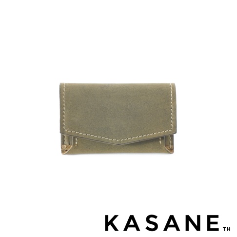 北海道KASANE 職人手作義大利Texas皮革迷你雙折短夾，呈現灰綠色皮革材質，正面有對稱的車線設計，下方有品牌 KASANE TH 商標。