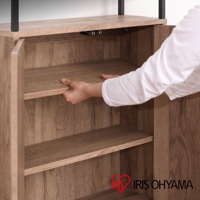 淺木紋色鐵木材質櫥櫃，展示一隻手正在調整中間層板，櫥櫃內有兩層層板，頂部有黑色金屬支架。