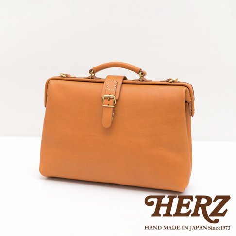 職人手作皮革軟式杜勒斯包，經典棕色，採用柔軟皮革材質，搭配金色金屬扣環與提把，展現復古質感。