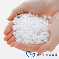 雙手捧著大量白色、圓柱狀的填充物，材質看起來是塑膠或類似的合成材料，這些填充物狀似細小的管狀顆粒，用於調節枕頭的軟硬度。