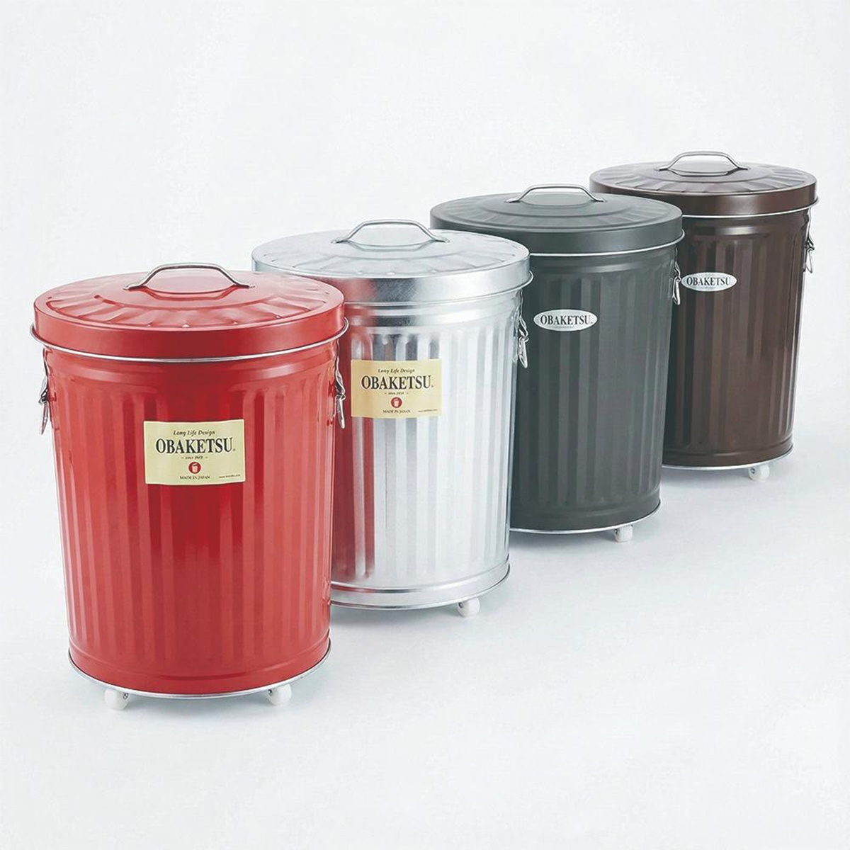 一排四個 Obrketu 附輪垃圾桶，分別為紅色、銀色、炭灰色和棕色，每個桶上都有 Obrketu 標籤，背景為白色。