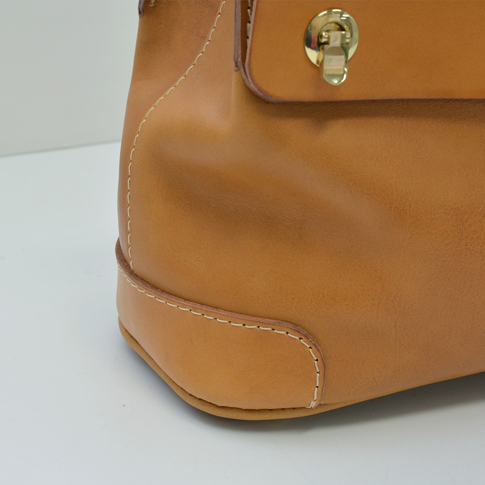 職人手作皮革旅行商務兩用波士頓包，展現自然棕色皮革紋理，搭配車縫線與金色旋轉鎖扣，細節精緻。