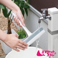 雙層紗窗刷，白色塑膠手柄，帶有灰色和白色雙層清潔頭，正在水龍頭下沖水，準備清潔。