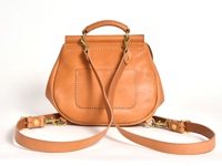 天然皮革製成的迷你後背包，呈現自然棕色，帶有手提把和可拆卸肩帶，以黃銅金屬扣件固定，包身後方有縫線裝飾的方形口袋。