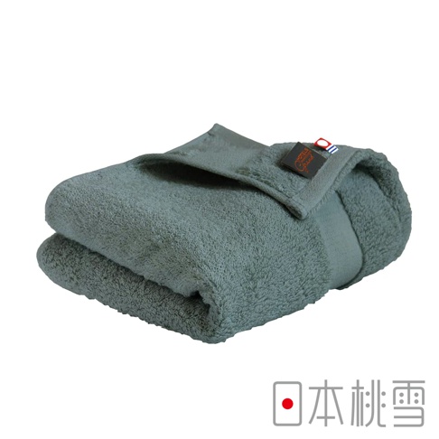 一條摺疊的灰色今治匹馬棉毛巾，帶有品牌標籤，毛巾材質柔軟，質地蓬鬆。