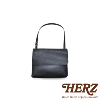 黑色皮革經典郵差包，帶有可調節的細肩帶，包身為簡潔的方形設計，翻蓋式封口。