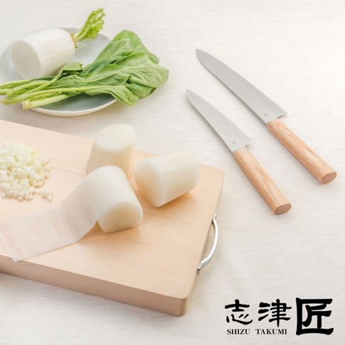 兩把Yuri / Petit knife水果刀，刀刃為銀色不鏽鋼，刀柄為淺木色。旁邊有切塊的白蘿蔔、青菜及切碎的蒜末，擺放在木質砧板上。