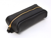 黑色皮革製成的圓角筆袋，配有金色拉鍊和皮革拉環，整體簡約大方。