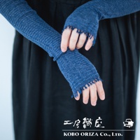 一雙深藍色針織有機棉袖套，袖口有流蘇設計，露出手指，搭配黑色服裝。