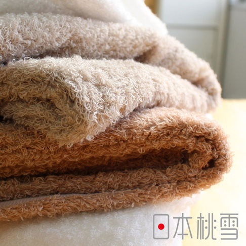 疊放的Furry雙股紗絨毛吸水浴巾，呈現米白、淺棕、深棕等柔和色調，材質柔軟蓬鬆，質地細膩。