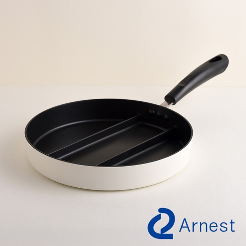 一個白色外觀的Arnest品牌三格分隔不沾平底鍋，放置在淺色背景上，平底鍋擁有黑色內壁與手把，鍋內設有三個分隔區域，適合同時烹飪多種食材。
