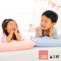 粉色與淺藍色枕頭，各有一名孩童趴臥其上，皆面帶笑容。