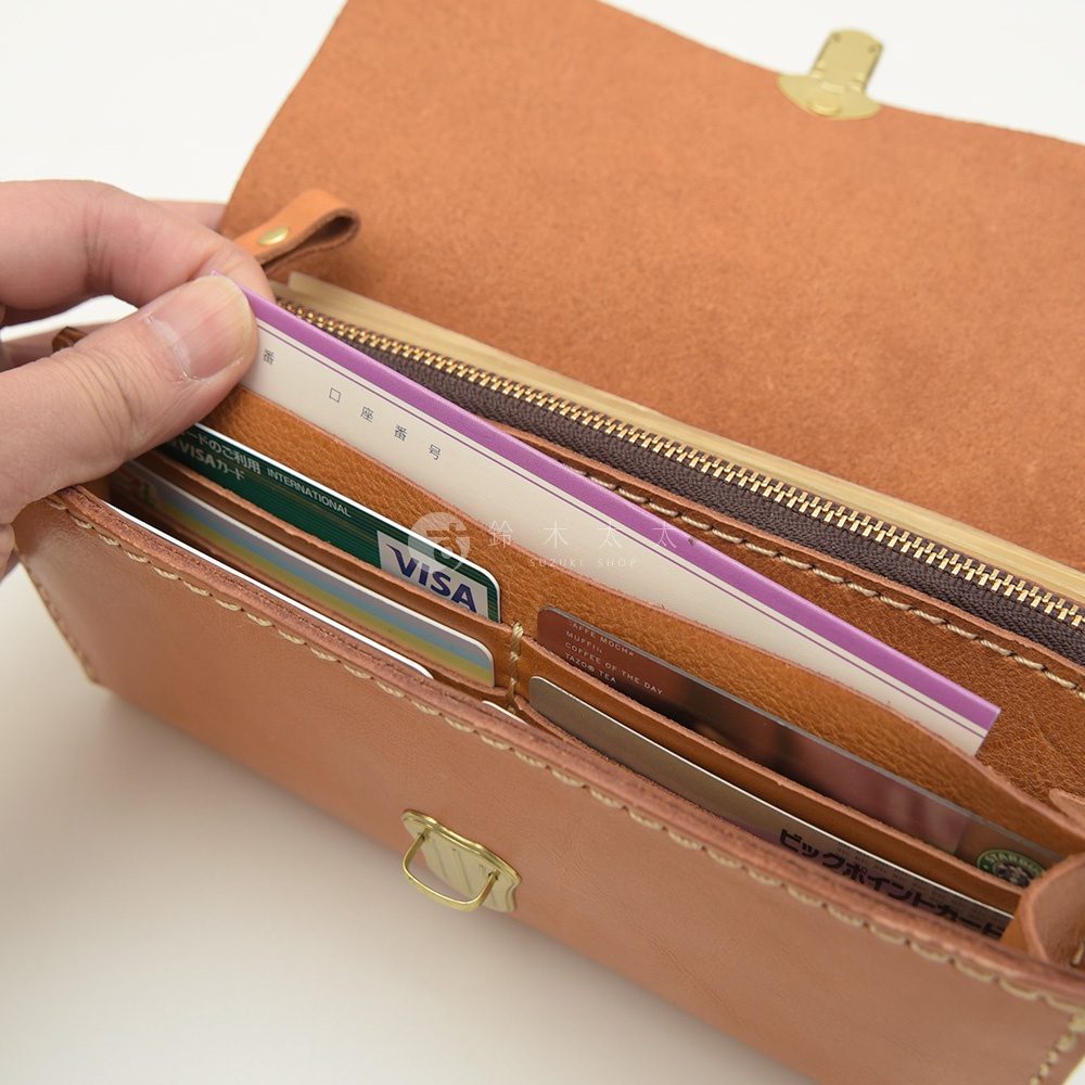 職人手作淺棕色皮革長夾，手風琴式多卡層設計，內有信用卡、日文卡片，搭配金色金屬釦。