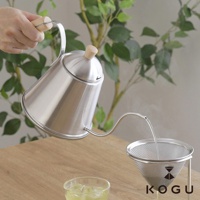 日製18-8不鏽鋼木柄極細口咖啡手沖壺，銀色壺身搭配木質壺蓋與提把，正在透過細長壺嘴向濾杯注入水流。