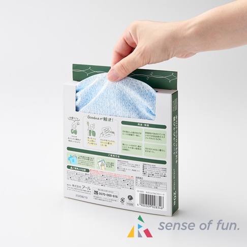 一隻手從印有日文說明與圖示的白色紙盒中抽出藍色、帶有細緻紋理的兩用清潔巾。