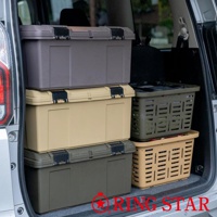 四個深淺不一的灰色和卡其色塑膠收納箱堆疊在車廂內，其中兩個箱子是封閉式的，帶有黑色鎖扣；另外兩個是鏤空網格狀的籃子，分別為軍綠色和卡其色。