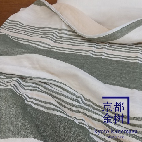 米白色與淺綠色條紋的六層紗材質毯子，材質柔軟，帶有文青風格。