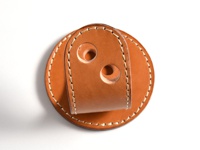 職人手作皮革兩入用筆架 (KZ-109)，採用棕色皮革製成，圓形底座搭配一個向上彎曲的皮革片，皮革片上有兩個圓形筆孔，邊緣以米色縫線縫合。