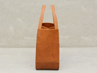 職人手作皮革Organ方形托特包 (G-68) M，呈現簡潔的方形輪廓，採用天然棕色皮革製作，質感細緻。包身縫線清晰，提把為圓弧形設計，整體風格樸實而耐用。