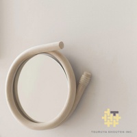 藤編圓鏡，鏡框為天然藤條彎曲而成，呈現獨特的螺旋造型，鏡面為圓形，整體色調為淺木色。