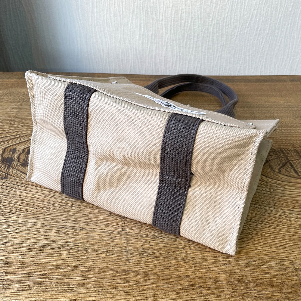 米白色純棉帆布迷你托特包，配有深灰色織帶裝飾及提把，包身側面有品牌標誌。