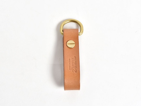 職人手作皮革吊掛扣帶，淺棕色天然皮革，附有黃銅D形環和螺絲固定，皮革上壓印有「HERZ」品牌標誌及「MADE IN JAPAN」字樣。