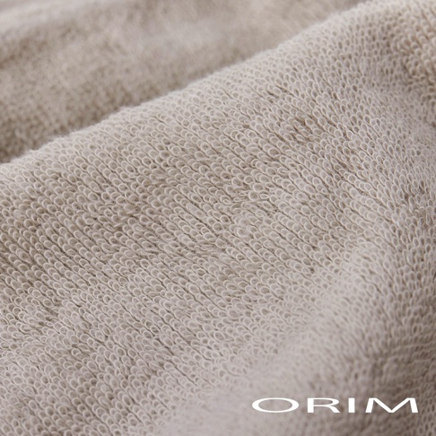 米色今治毛巾材質，表面有細緻的毛圈紋理，織物質地柔軟，光線下呈現柔和光澤。