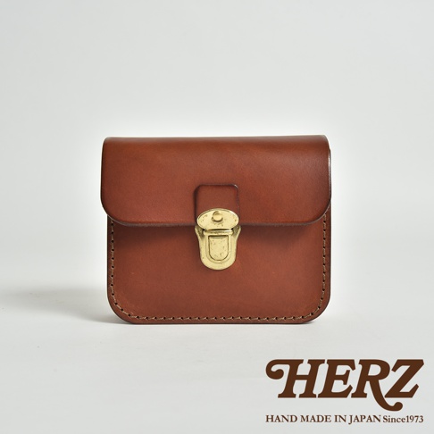 一個棕色皮革製作的腰包，帶有金屬鎖扣，整體設計簡潔，縫線清晰可見。