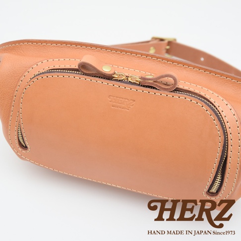 HERZ 職人手作皮革拉鍊旅行斜背包，設有雙拉鍊夾層，採用堅固耐用的皮革材質，並印有MADE IN JAPAN字樣。