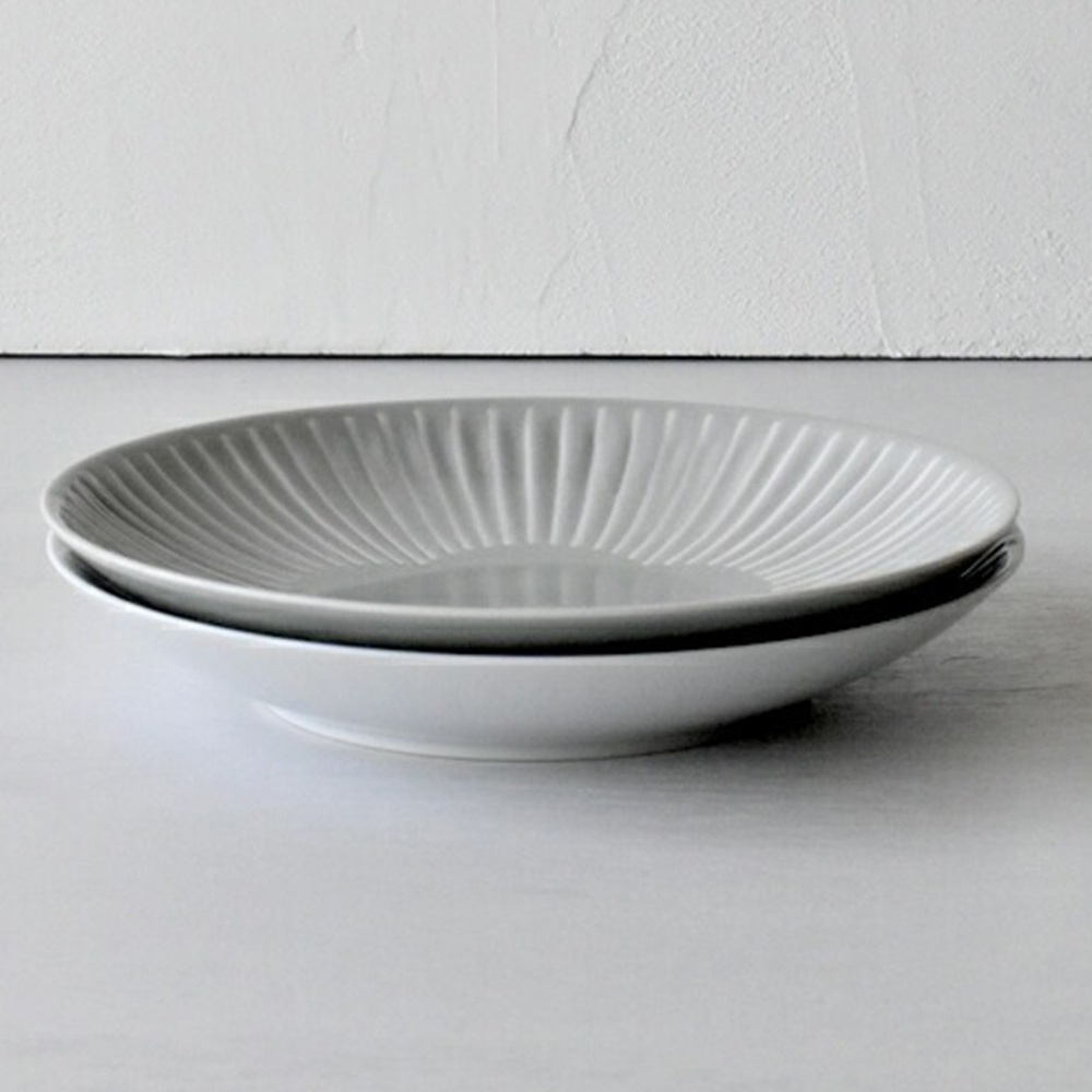 兩件式主食盤，上層為淺灰色，帶有放射狀刻紋，材質為陶瓷；下層為白色，盤面較淺，材質同為陶瓷。